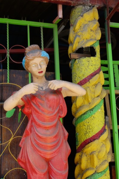 painted but dusty  statue of woman in toga