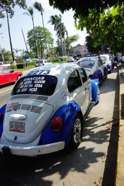 Blue-and-white VW bugs are taxis.