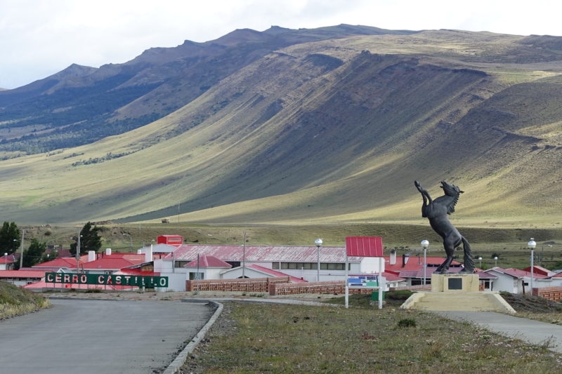 Village, flatlands rising to mountains, horse statue.