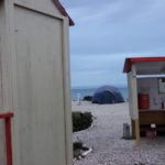 Tent on beach with wash and toilet facilities nearby.
